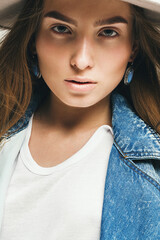 portrait of woman in hat and denim waistcoat