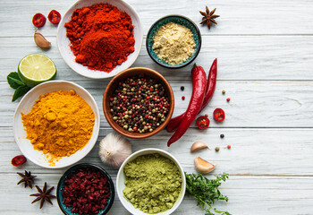 Various spices  on white wooden background, top view