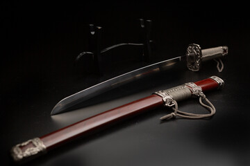 Beautiful katana sword with sheath and stand on a black background