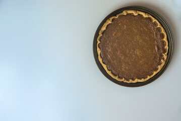 Thanksgiving background. Top view of pie. Delicious pumpkin pie with fresh mint leaves on light gray background with copy space. Man cooking. Dublin, Ireland