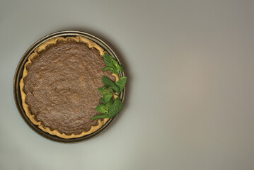 Thanksgiving background. Top view of pie. Delicious pumpkin pie with fresh mint leaves on light gray background with copy space. Man cooking. Dublin, Ireland