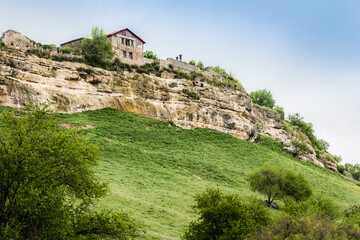 Fototapeta na wymiar Medieval building on a high cliff above the mountain valley in the famous ancient city-fortress of Chufut-Kale (