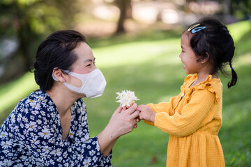 Obraz premium little girl give her mother fragrance Indian Cork at field.