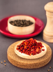 dried red chilli or paprika flakes on wooden plate