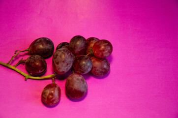 a bunch of red grapes on a purple background