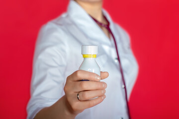 doctor woman in white coat holding a bottle with medicine