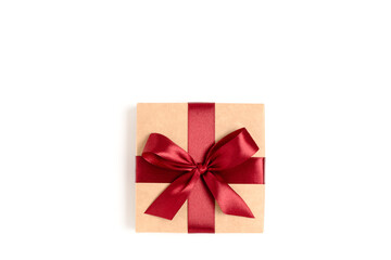 Gift box tied with red ribbon on a white background. Festive minimal composition.