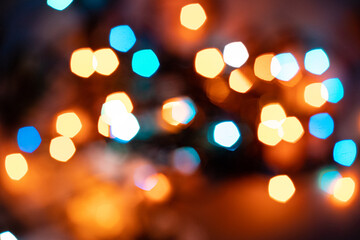 Blurry colored lights on a dark background. Bokeh style. New Year and Christmas background.