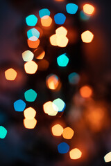 Blurry colored lights on a dark background. Bokeh style. New Year and Christmas background. Social media vertical content.