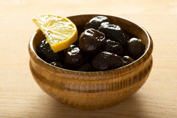 a plate of olives and a lemon slice