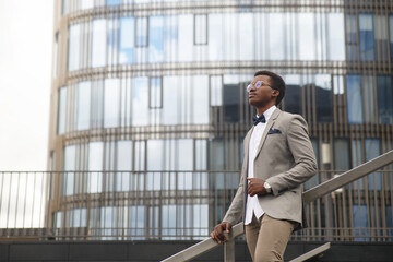 Cute black male businessman on the background of an office building.