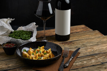 Italian ravioli stuffed with meat closeup on a black plate. rustic style