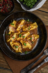 Italian ravioli stuffed with meat closeup on a black plate. rustic style