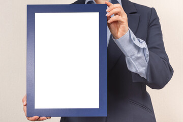 mockup diploma. woman dressed in a business suit holds a mockup of a diploma in front of her. Certificate, diploma, picture, gratitude blue blank frame mockup