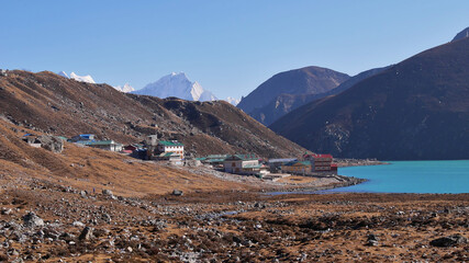 Small Sherpa village Gokyo (4,860 m), Sagarmatha National Park, Himalayas, Nepal located on the shore of turquoise colored third lake on popular Three Passes Trek in the afternoon sun.