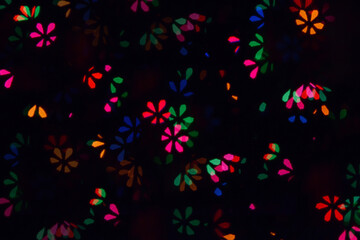 Fototapeta na wymiar Bokeh lights background. Flowers bokeh defocused background. Holiday background. Garland. Defocused blinks. New Year. Bokeh retro style photo.