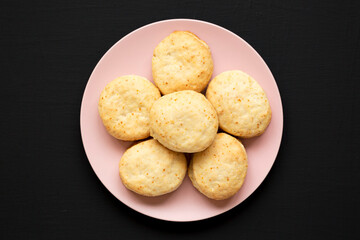 Homemade Flaky Buttermilk Biscuits on a pink plate on a black surface, top view. Flat lay, overhead, from above.