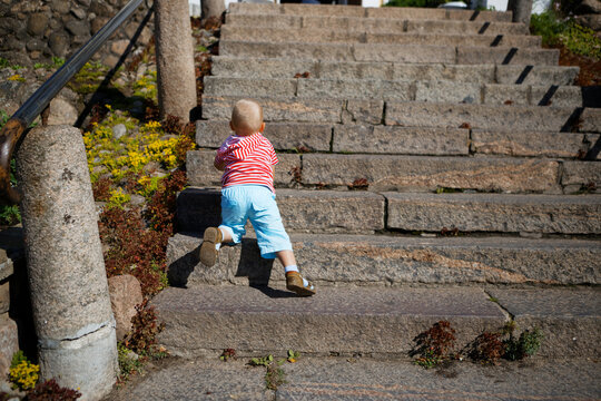 Child Playing On A Steep Stone Staircase