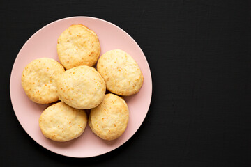 Homemade Flaky Buttermilk Biscuits on a pink plate on a black background, top view. Flat lay, overhead, from above. Space for text.