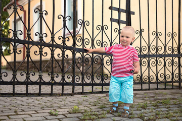 a child plays by a wrought iron grate