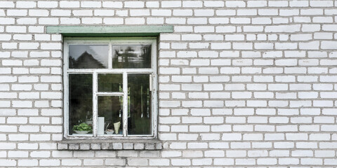 window with old wooden frame on white brick wall of village house