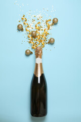 Blank champagne bottle and glitter on blue background