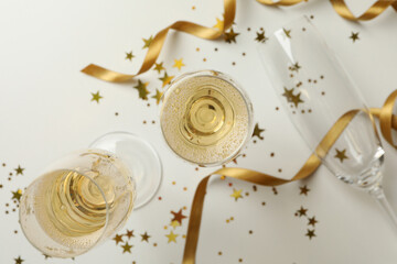 Champagne glasses and glitter on white background
