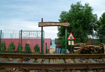 Fototapeta na wymiar Acceso junto a la vía del tren a la playa de Olimp en Rumanía. Acceso a la playa con el cartel de 