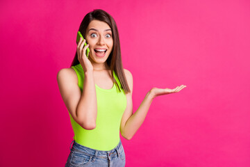 Fototapeta premium Photo of beautiful young girl amazed surprised shocked news gossip secret talk mobile cellphone isolated over pink color background