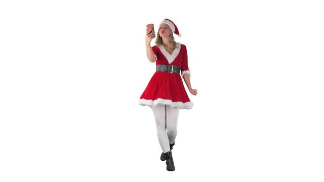 Modern Santa Claus girl walking and taking selfie photos kissing and waving at cellphone. Full length isolated on white background.