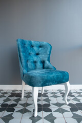 Modern design home interior with elegant blue chair in retro style over gray wall. Stylish home decor