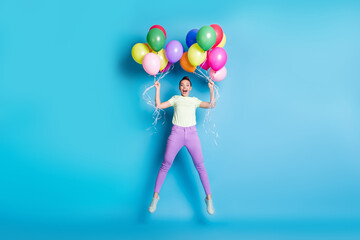 Fototapeta na wymiar Full length body size photo of amazed crazy girl jumping keeping air balloons shouting loudly isolated on vivid blue color background