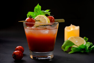 Bloody Mary cocktail with a candle and ingredients