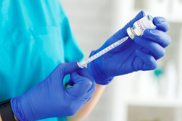 Doctor hands holding covid-19 vaccine preparing for vaccination of a patient
