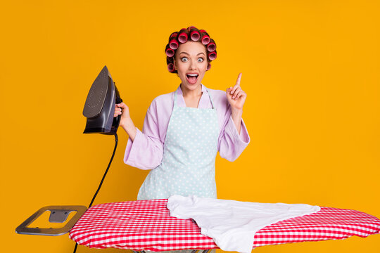 Portrait Of Attractive Glamorous Cheerful Mom Using Iron Pointing Up Solution Isolated Bright Yellow Orange Color Background