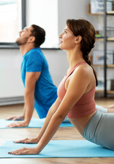 sport, fitness, lifestyle and people concept - smiling man and woman exercising at home