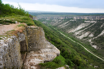 House built in a cave on a high cliff above the mountain valley in the famous ancient city-fortress of Chufut-Kale (