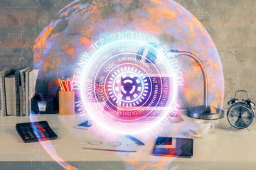 Computer on desktop in office with technology theme hologram. Double exposure. Tech concept.