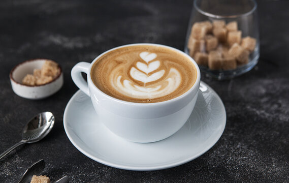aromatic cappuccino in a white cup on a dark background.