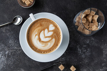 aromatic cappuccino in a white cup on a dark background.