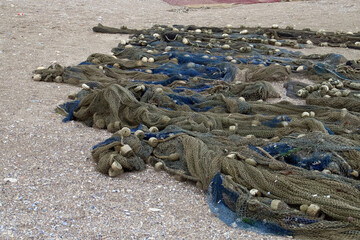 Redes de pesca extendidas sobre la arena en la playa. Redes de pesca tradicionales secándose al aire libre en la playa de Olimp, Rumanía.