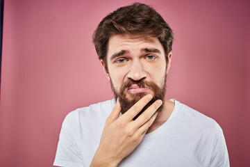 bearded man in white t-shirt emotions displeased facial expression studio pink background