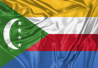 Obraz premium Comoros flag waving in the wind. National flag on satin cloth surface texture. Background for international concept.