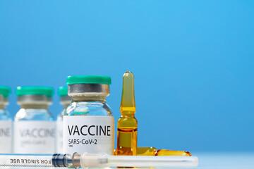 Sars-cov-2 vaccine vial and syringe on white table