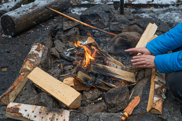 Women's hands by the fire. Cropped photo