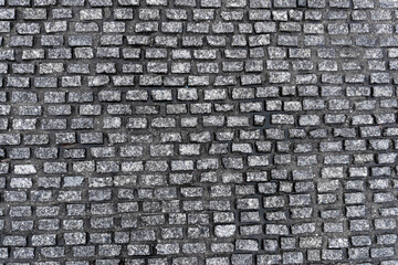 autumn wet dark gray pavement roadway with small stones in Europe. texture background