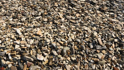 brown warm textured background of natural round sea stones as a basis for design, advertising and text writing, rocky beach texture as a backbone for any ideas