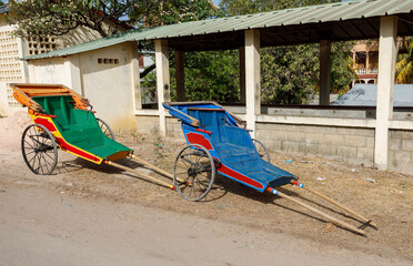Pulled rickshaw in street of north Madagascar. Human-powered rickshaws is mode of transport in many...