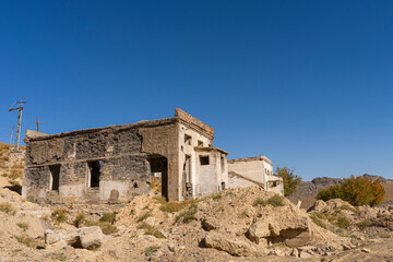 An old abandoned factory in the mountains. Fragments of destroyed buildings. Mountains.Ruins of a poly metal factory.Abandoned industrial production.The ruins of a mining and processing plant.Blue sky