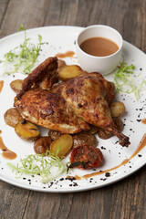 Grilled chicken Tabaka with baked potatoes and with sauce